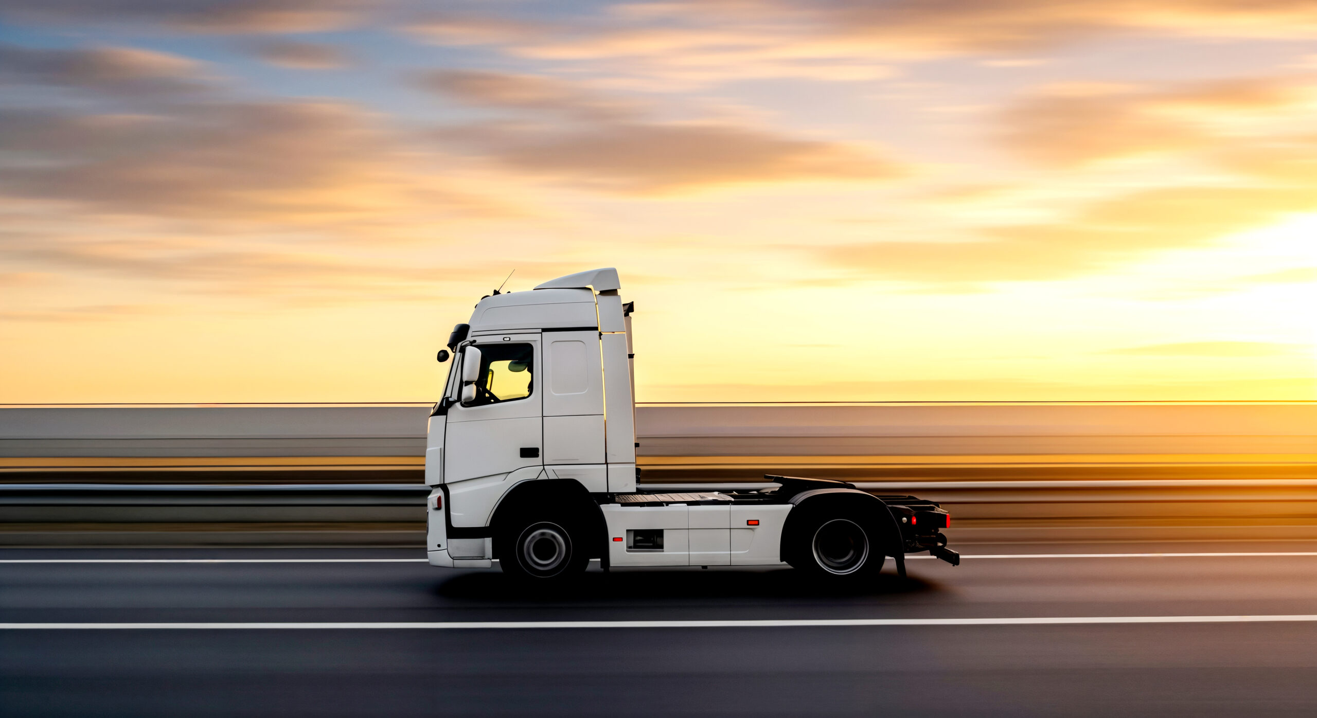 white-semi-truck-driving-highway-sunset